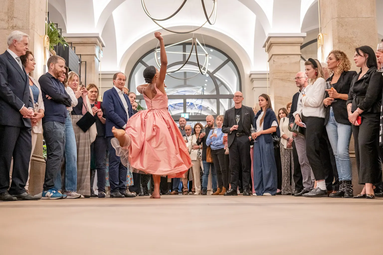Tänzerin im rosa Kleid performt vor Gästen in der Lobby der Imperial Riding School